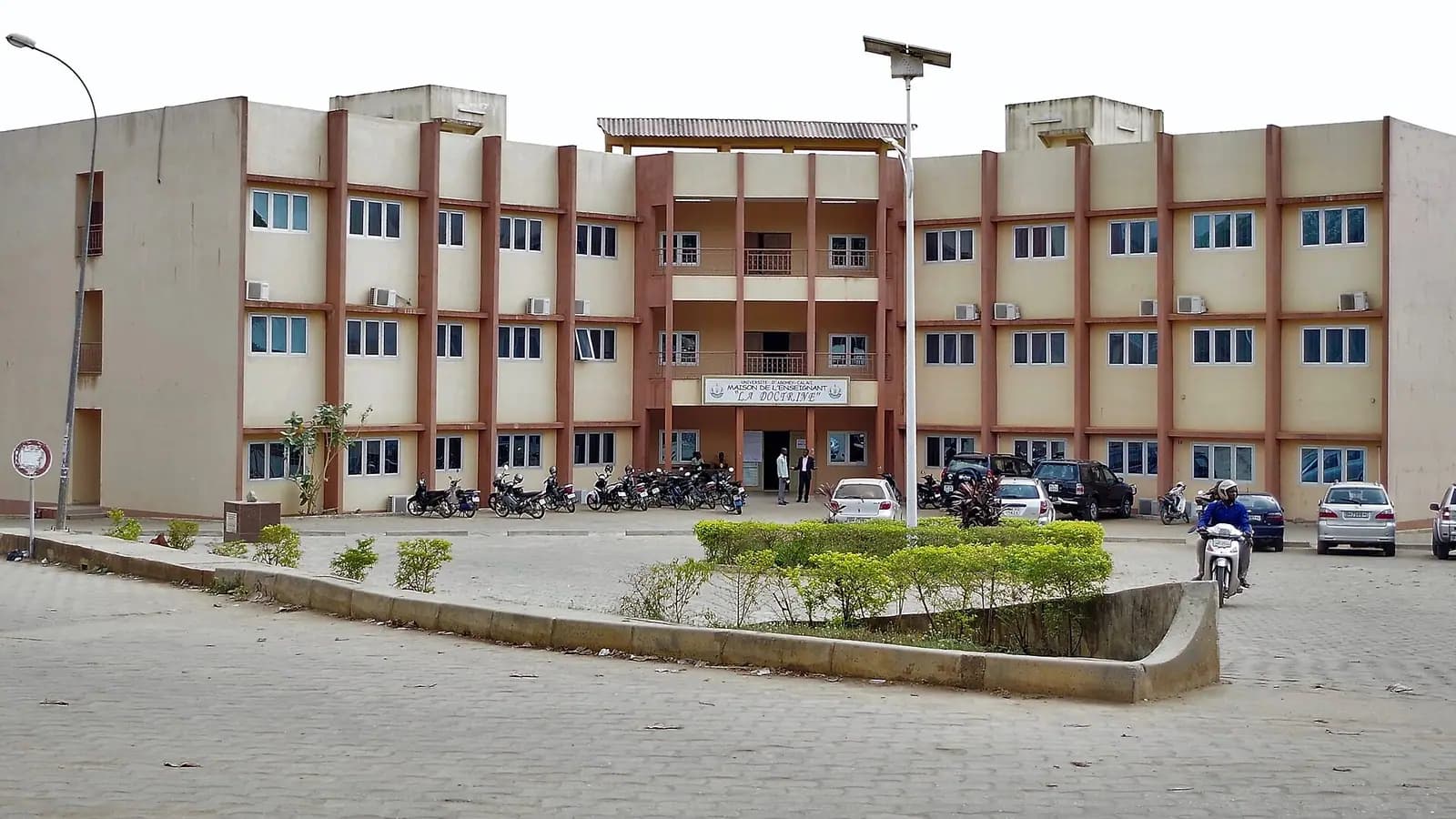 La Maison de l'enseignant de l'Université d'Abomey-Calavi, bâtiment de trois étages face à une place pavée